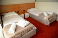 a hotel room with two beds and a red carpet at Holiday Resort in Velika Slatina