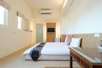 a bedroom with a large white bed and a table at 開心居-正市中心電梯民宿-步行東大夜市5分鐘 in Hualien City