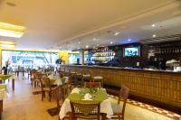 a restaurant with tables and chairs and a bar at Tri Hotel Executive Caxias in Caxias do Sul