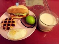 a plate of food with a sandwich and waffles and a glass of milk at Sunny Homestay in Ji&#39;an