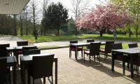 a group of tables and chairs in a park at KYRIAD ROUEN NORD - Mont Saint Aignan in Mont-Saint-Aignan