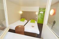 a small room with two beds and a chair at Campanile Hotel Compiegne in Compiègne