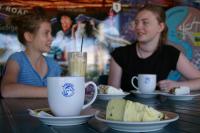 卡伦巴Ash's Holiday Units的两个坐在餐桌上,配上食物盘的女人