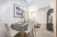 a dining room with a table and white chairs at Apartment Irene in Poreč