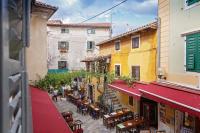 a view of an alley with tables and chairs and buildings at Apartment Irene in Poreč
