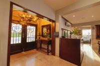 Una sala de estar con una puerta, una mesa y una lámpara de araña. en Best Western Plus San Jorge, en Ciudad Obregón