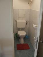 a small bathroom with a toilet and a red rug at Erdélyi vendégház in Sárospatak