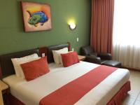 Una habitación de hotel con una cama grande con almohadas rojas. en Hotel Enriquez, en Coatzacoalcos
