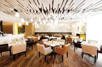 Un restaurante con mesas y sillas y una lámpara de araña. en Tikal Futura Hotel & Convention Center, en Guatemala