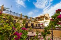 a building with a balcony with pink flowers in the foreground at Riad 53 Fes - Luxury Oasis in Fès