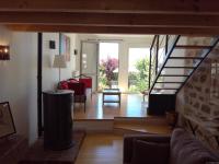 a living room with a staircase and a living room with a couch at Gîte du Besset in Pradelles