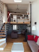a loft apartment with a staircase and a living room at Gîte du Besset in Pradelles