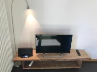 a television sitting on a wooden table with a lamp at Blackbird´s Nest in Wiesenbronn
