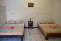 two twin beds in a room with a table at Hotel Sol Puntarenas in Puntarenas