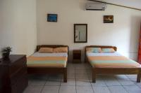 a bedroom with two beds and a dresser and a mirror at Hotel Sol Puntarenas in Puntarenas