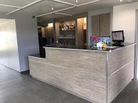 a bar with a wooden counter in a room at Kyriad Cambrai in Cambrai