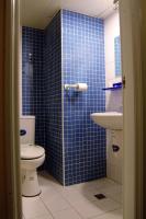 a blue tiled bathroom with a toilet and a sink at Hwa Hong Hotel in Kaohsiung