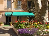 un jardin fleuri en face d&#39;un bâtiment avec un arbre dans l&#39;établissement Hotel De Provence, à Digne-Les-Bains