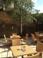 a patio with tables and chairs and a tree at Prinzhotel Rothenburg in Rothenburg ob der Tauber