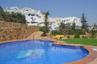 Una gran piscina azul con edificios al fondo. en Hotel Simón, en Mojácar
