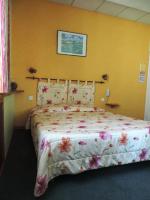 - une chambre dotée d&#39;un lit avec un couvre-lit floral dans l&#39;établissement Hotel De Provence, à Digne-Les-Bains
