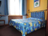 - une chambre avec un lit doté d&#39;un couvre-lit bleu et jaune dans l&#39;établissement Hotel De Provence, à Digne-Les-Bains