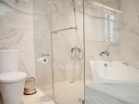 a white bathroom with a toilet and a shower at KDM Hotel in Taipei