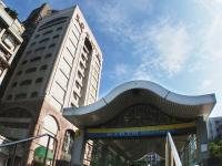 a building with a curved roof in a city at KDM Hotel in Taipei