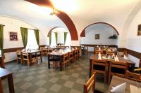 una sala da pranzo con tavoli e sedie in legno di Hotel Club a Vranovská Ves