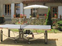 a picnic table with an umbrella in front of a house at La Maison de Mireille in Le Puy-en-Velay