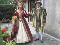 a man and woman dressed in costumes standing next to a building at La Maison de Mireille in Le Puy-en-Velay