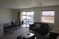 a living room with a couch and a table at Pegasus Gateway Motels &amp; Apartments in Rangiora