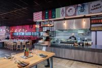 a restaurant with tables and people in the kitchen at Ibis Styles Hobart in Hobart