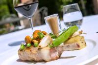 a plate of meat and vegetables with a glass of wine at Le Manoir de Gressy in Gressy