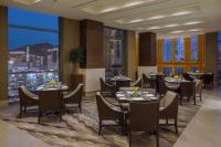 um restaurante com mesas e cadeiras e vista para a cidade em Jabal Omar Hyatt Regency Makkah em Meca