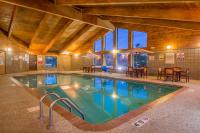 una piscina en un edificio con mesas y sillas en AmericInn by Wyndham Ames, en Ames