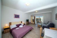 ein Schlafzimmer mit einem Bett und ein Wohnzimmer mit einem Sofa in der Unterkunft Apartments Kovačić in Makarska