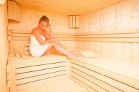 Eine Frau, die in einer Sauna sitzt. in der Unterkunft Park Hotel Diament Katowice in Kattowitz