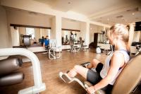 eine Frau, die auf einem Laufband in einem Fitnessstudio sitzt in der Unterkunft Park Hotel Diament Katowice in Kattowitz
