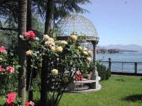 a gazebo with a bench and flowers at Hotel Villa Ruscello in Baveno