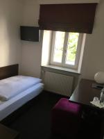 a bedroom with a bed and a window and a table at Hotel Bergbauer in Neuburg an der Donau