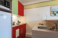 a kitchen with red cabinets and a sink at Résidence Pierre &amp; Vacances Electra in Avoriaz