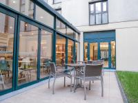 a patio with chairs and tables and windows at ibis Paris Bastille Faubourg St Antoine in Paris