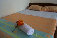 a towel on a bed with a flower on it at Hotel Sol Puntarenas in Puntarenas