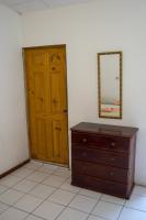 a room with a wooden door and a dresser and a mirror at Hotel Sol Puntarenas in Puntarenas