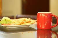 a plate of food on a table next to a red mug at Love in Hualien B&amp;B in Hualien City