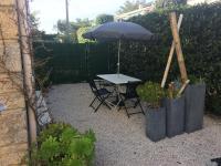 a table and chairs with an umbrella in a garden at Les Lones avec jardin in Six-Fours-les-Plages