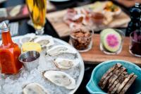 Una mesa con un plato de ostras y una bebida. en The Durham Hotel, en Durham