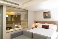a bedroom with a bed and a large mirror at Just Sleep Kaohsiung Zhongzheng in Kaohsiung