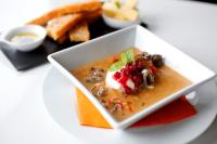 un plato blanco con un tazón de comida en una mesa en Unstad Arctic Resort, en Unnstad